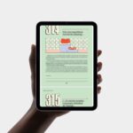 Mão segurando tablet exibindo livro digital.